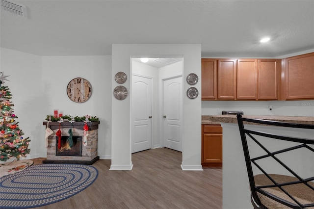 kitchen featuring a stone fireplace and light hardwood / wood-style flooring