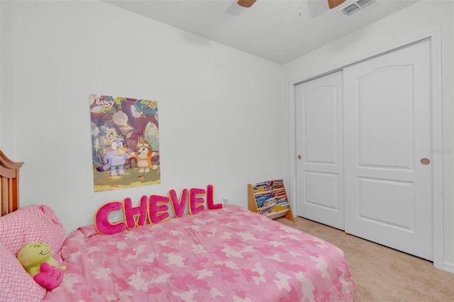 bedroom with ceiling fan, a closet, and light carpet