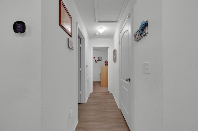 hallway featuring light hardwood / wood-style floors and a textured ceiling