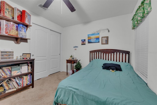 bedroom featuring ceiling fan, a closet, and light colored carpet