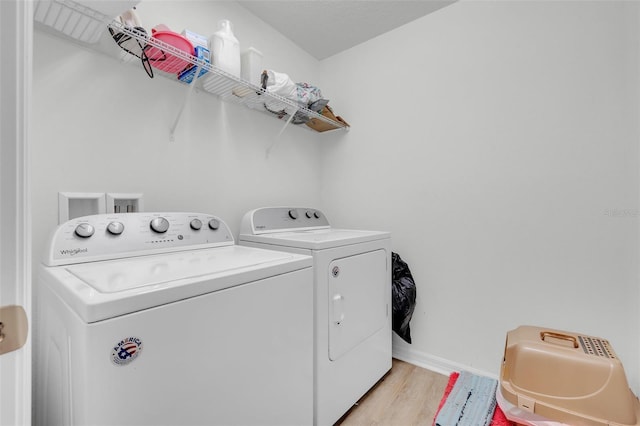 washroom with washer and clothes dryer and light hardwood / wood-style flooring