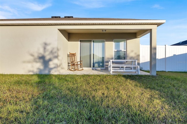 rear view of property with a lawn and a patio area