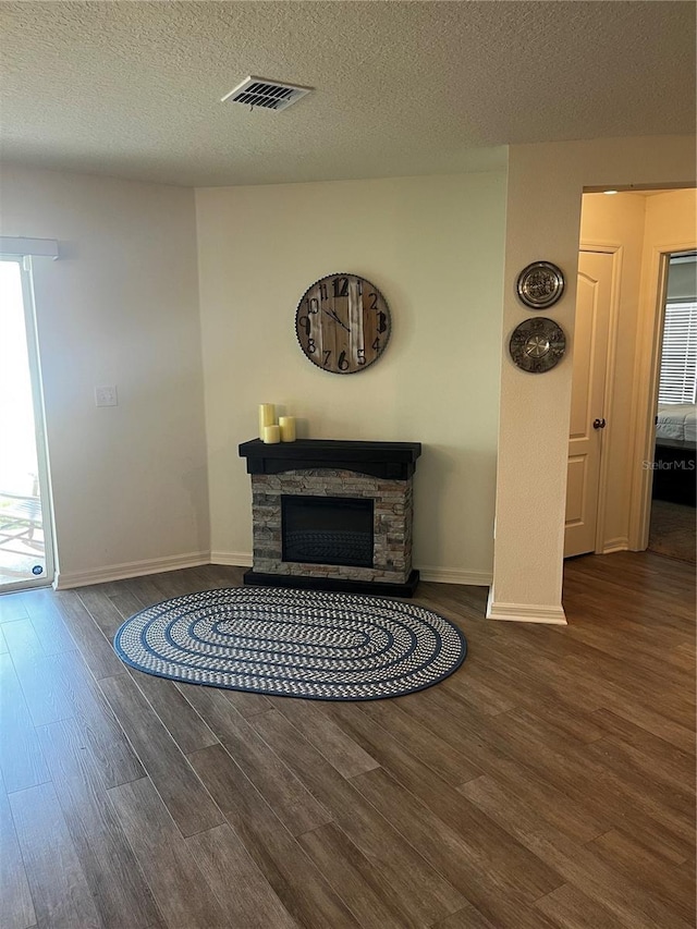 2325 Crossandra St, Mascotte, FL 34753 - living room featuring wood finished floors, a textured ceiling, and a stone fireplace