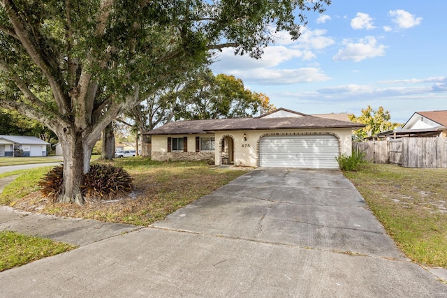 single story home with a garage and a front lawn