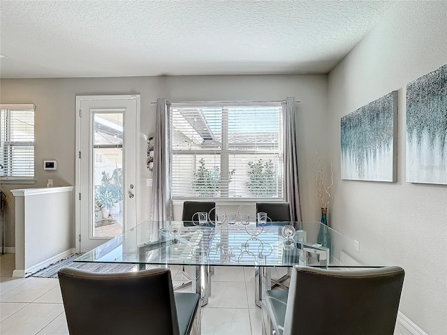 tiled dining area featuring a textured ceiling