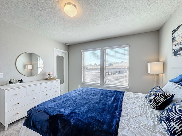 bedroom with a textured ceiling and light carpet