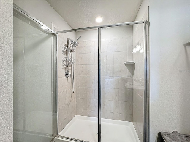 bathroom with a textured ceiling and walk in shower