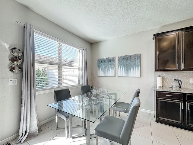 tiled dining room with a textured ceiling