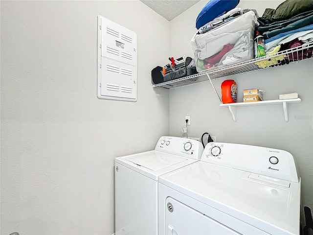 washroom with washer and dryer and a textured ceiling