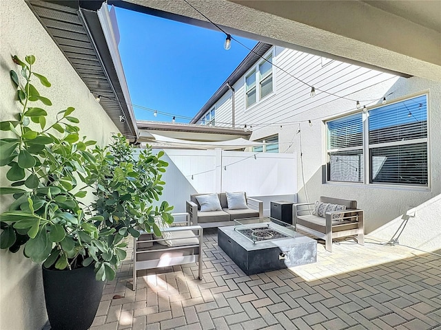 view of patio with an outdoor living space with a fire pit