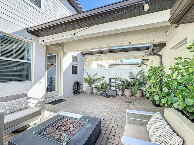 view of patio with an outdoor living space with a fire pit