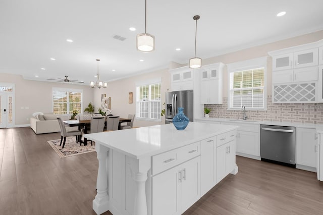 kitchen featuring white cabinets, appliances with stainless steel finishes, a center island, and ceiling fan