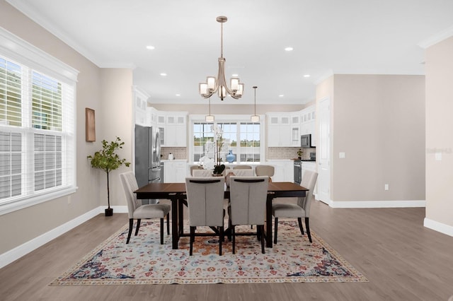 dining room featuring hardwood / wood-style floors, an inviting chandelier, and ornamental molding