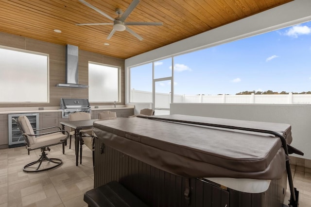 interior space with wine cooler, ceiling fan, grilling area, and a hot tub