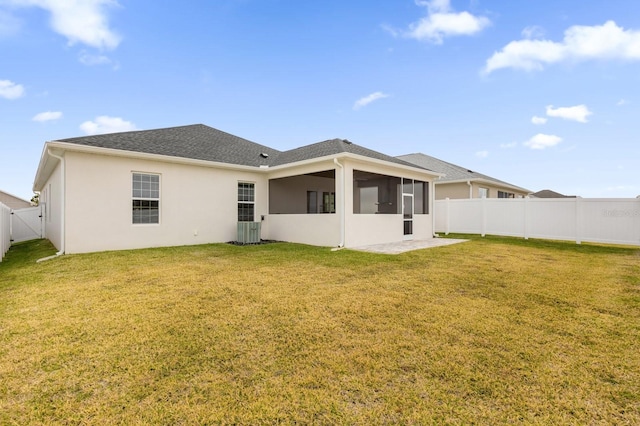 back of property with a yard, central air condition unit, and a sunroom