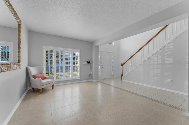 foyer featuring light tile patterned flooring and a textured ceiling