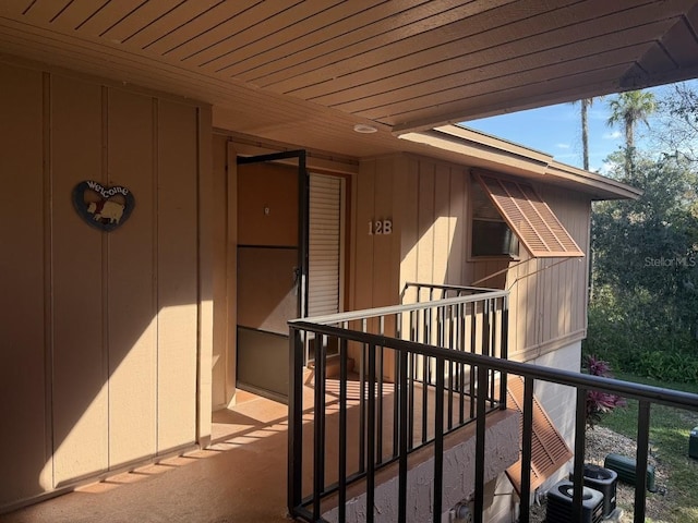 view of exterior entry with a balcony and central AC unit