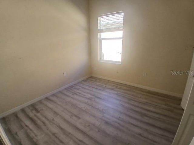 unfurnished room with hardwood / wood-style flooring