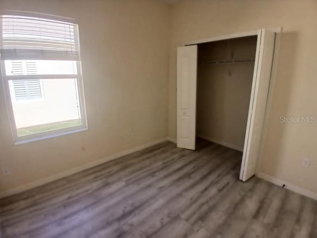 unfurnished bedroom with a closet and hardwood / wood-style flooring