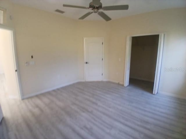 unfurnished bedroom featuring ceiling fan, light hardwood / wood-style floors, and a closet