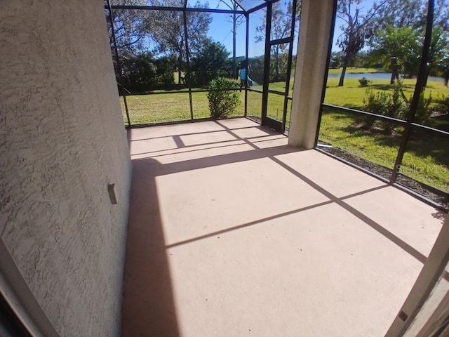 unfurnished sunroom featuring a water view