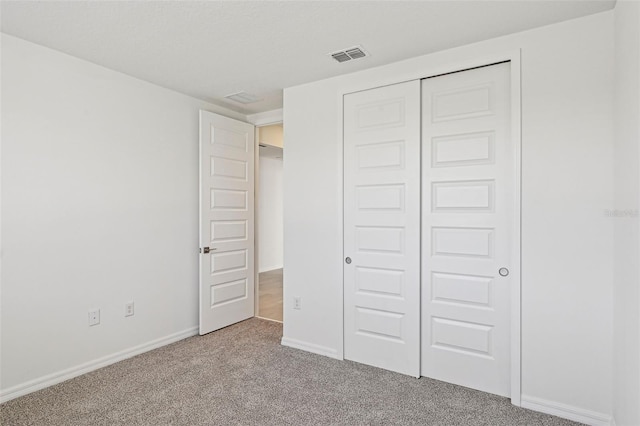 unfurnished bedroom with a closet and carpet flooring