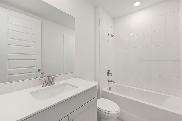 full bathroom with toilet, tiled shower / bath, and vanity