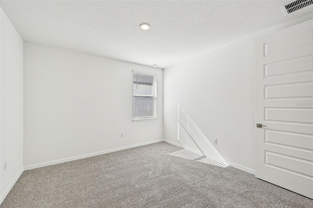 empty room featuring a textured ceiling and carpet floors