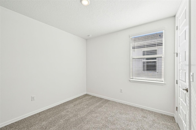 unfurnished room featuring light carpet and a textured ceiling