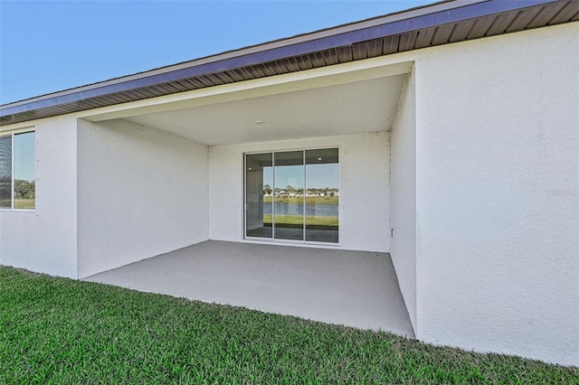 view of exterior entry with a lawn