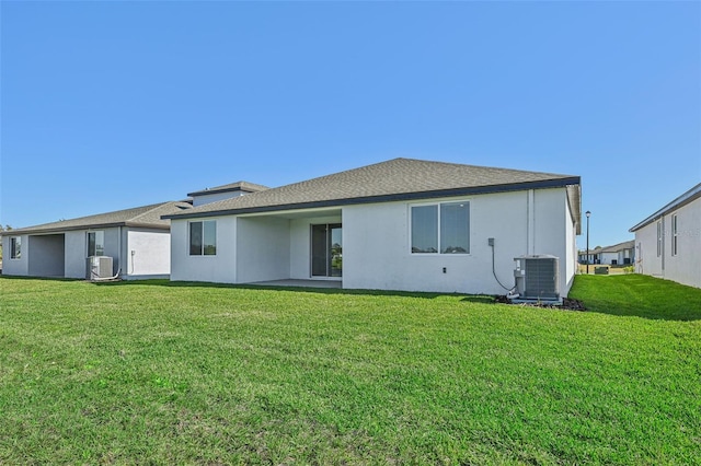 back of property with a lawn and central AC