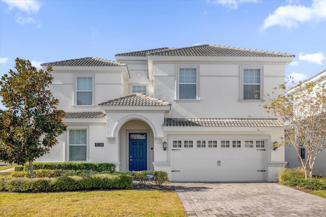 mediterranean / spanish home featuring a front lawn and a garage