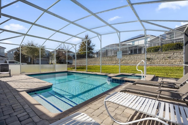 view of pool with glass enclosure, an in ground hot tub, and a patio