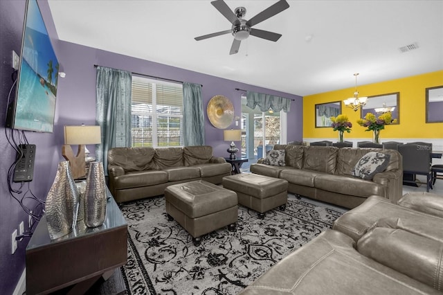 living room with ceiling fan with notable chandelier