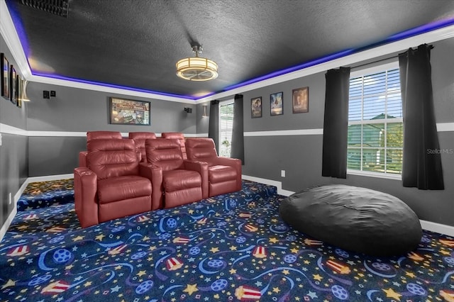 cinema room featuring crown molding, carpet, and a textured ceiling