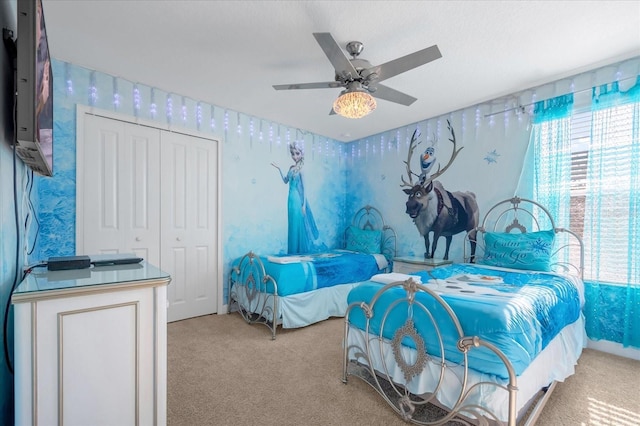 carpeted bedroom with ceiling fan and a closet