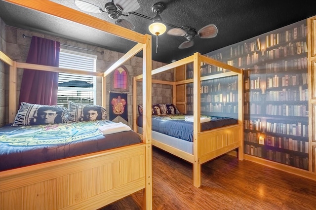 unfurnished bedroom with ceiling fan, wood-type flooring, and a textured ceiling