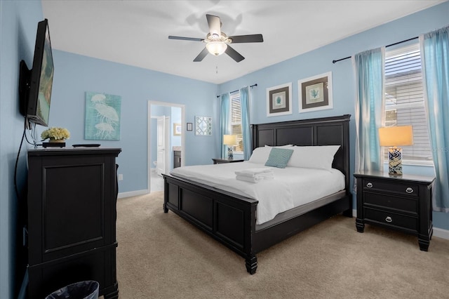 carpeted bedroom with ensuite bathroom and ceiling fan