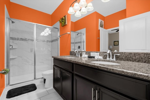 bathroom featuring tile patterned flooring, vanity, toilet, and a shower with shower door