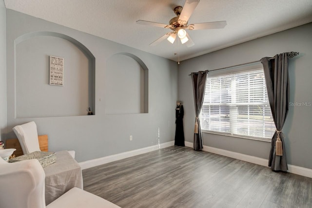 sitting room featuring a textured ceiling, hardwood / wood-style flooring, and ceiling fan