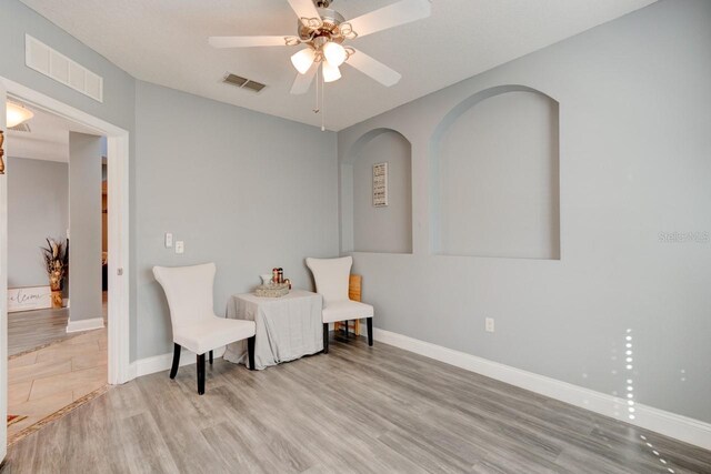 sitting room featuring ceiling fan and light hardwood / wood-style flooring