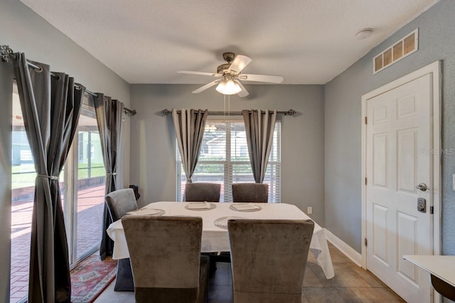 dining area with tile patterned flooring, a textured ceiling, and ceiling fan