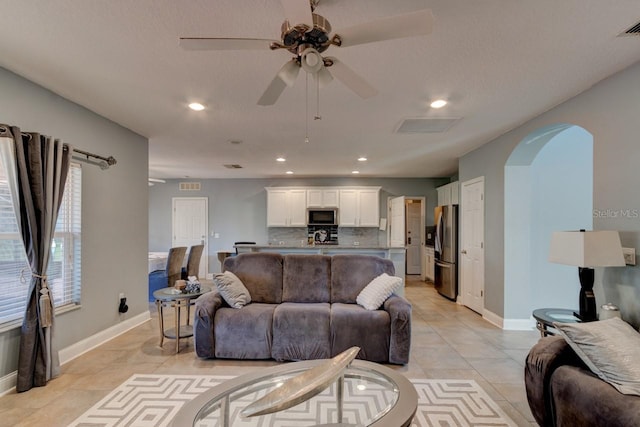 tiled living room with ceiling fan