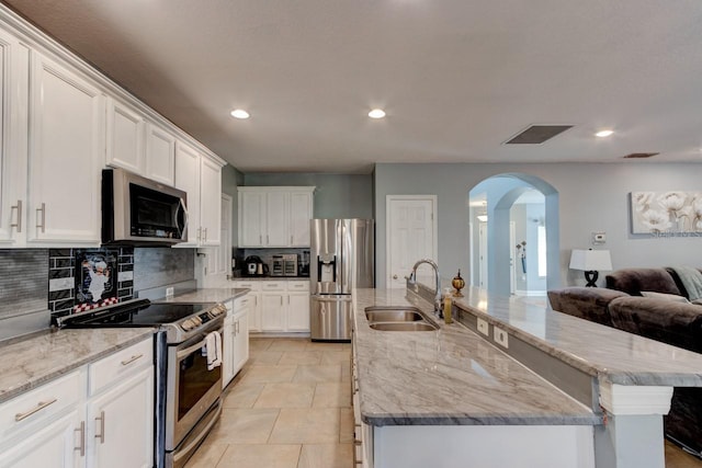 kitchen featuring white cabinets, appliances with stainless steel finishes, and a spacious island