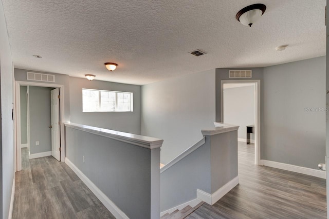 hall featuring hardwood / wood-style flooring and a textured ceiling