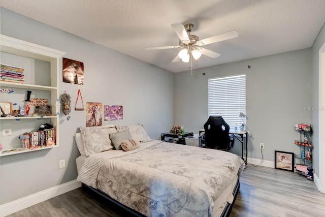 bedroom featuring hardwood / wood-style floors, ceiling fan, and a textured ceiling