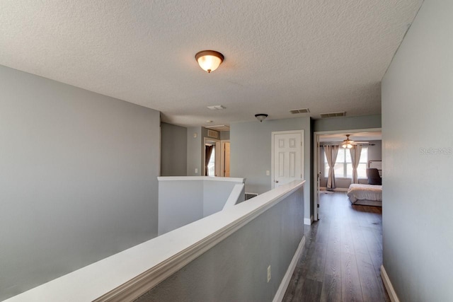 corridor with dark wood-type flooring and a textured ceiling