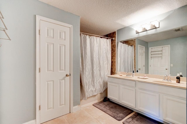 bathroom featuring tile patterned flooring, vanity, a textured ceiling, and shower / tub combo with curtain