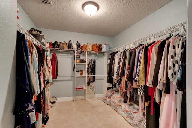 spacious closet with light tile patterned floors