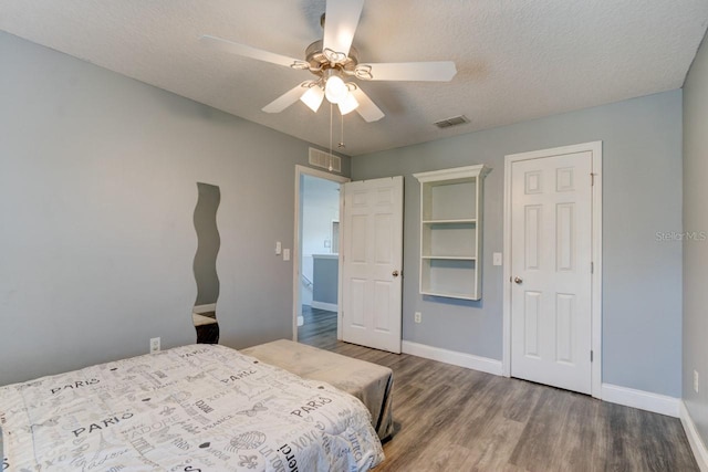 bedroom with a textured ceiling, hardwood / wood-style flooring, and ceiling fan